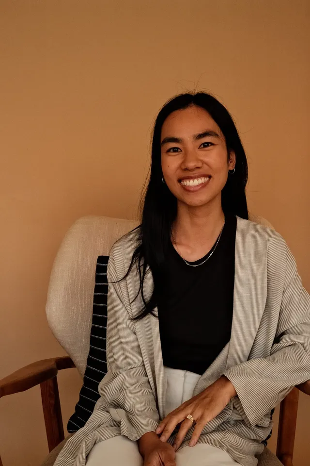 Bethany Ling, PsyD, postdoctoral fellow and therapist for intercultural couples and children, seated in an armchair at Coastal Therapy Group