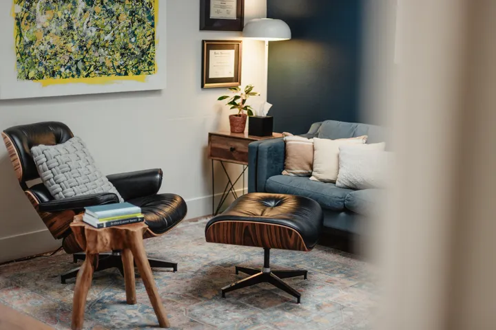 A quiet private therapy office in Carlsbad with a leather chair, ottoman, and couch