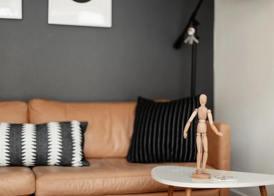 A wooden artist's mannequin standing on a side table in a Coastal Therapy Group office