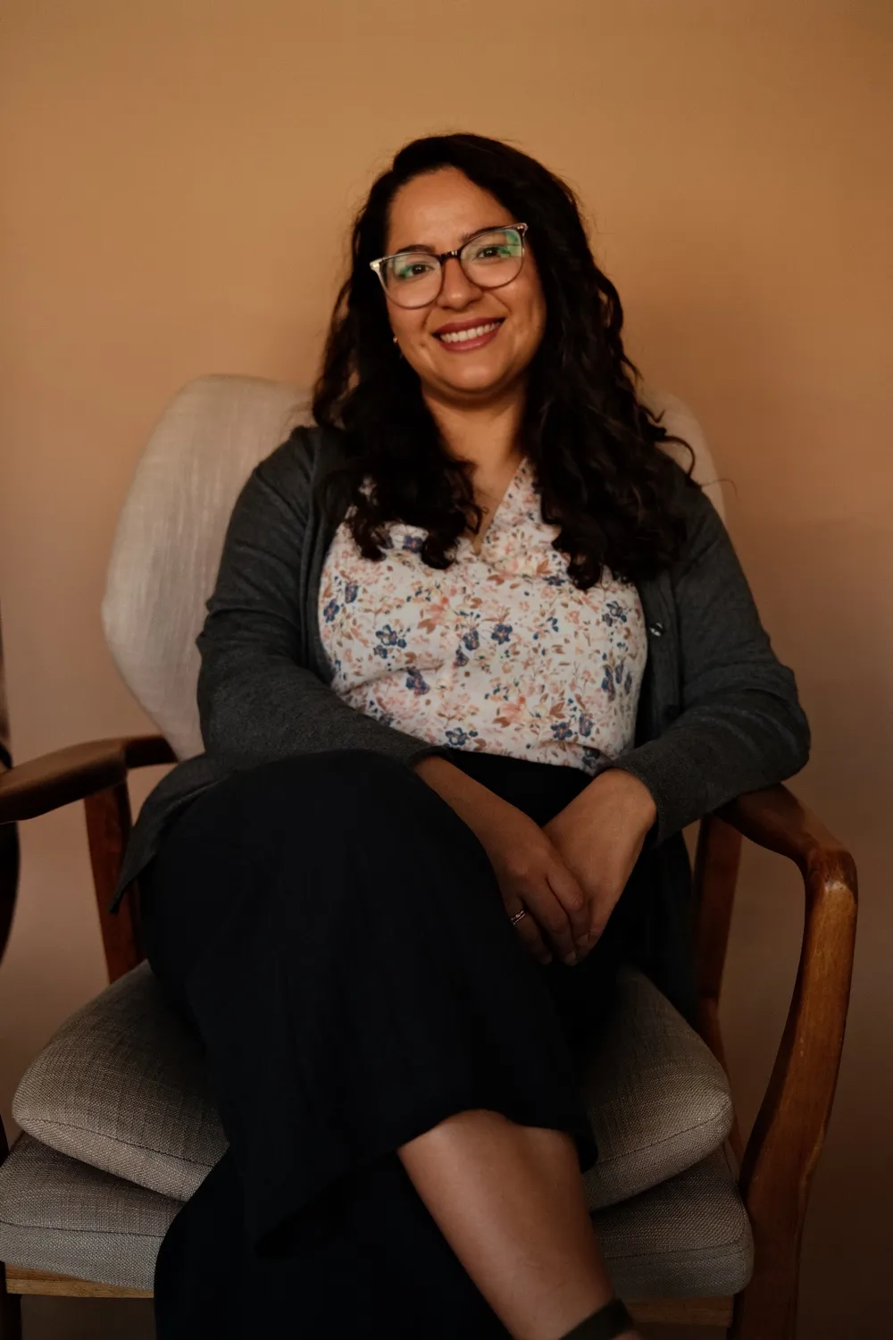 C. Julieta Aguilera Rice, PhD, psychologist in Carlsbad, CA, seated in a chair at the Coastal Therapy Group office