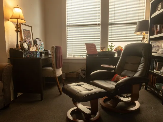 Leather armchair and ottoman beside a window and bookshelves in a therapy office at Coastal Therapy Group in Pasadena, CA