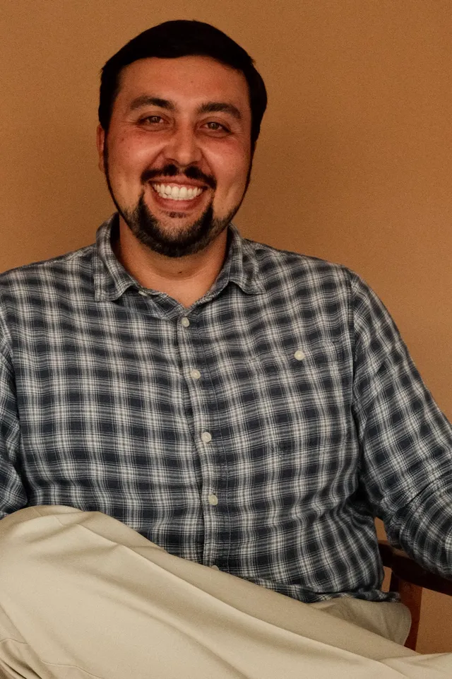 Sean Noe, PhD, postdoctoral fellow at Coastal Therapy Group, seated in a therapy office in North County San Diego